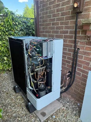 An outdoor heat pump with its cover removed for servicing